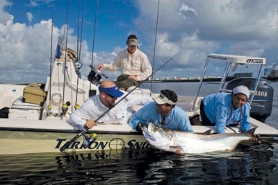 Fishermen holding a tarpon caught saltwater fishing